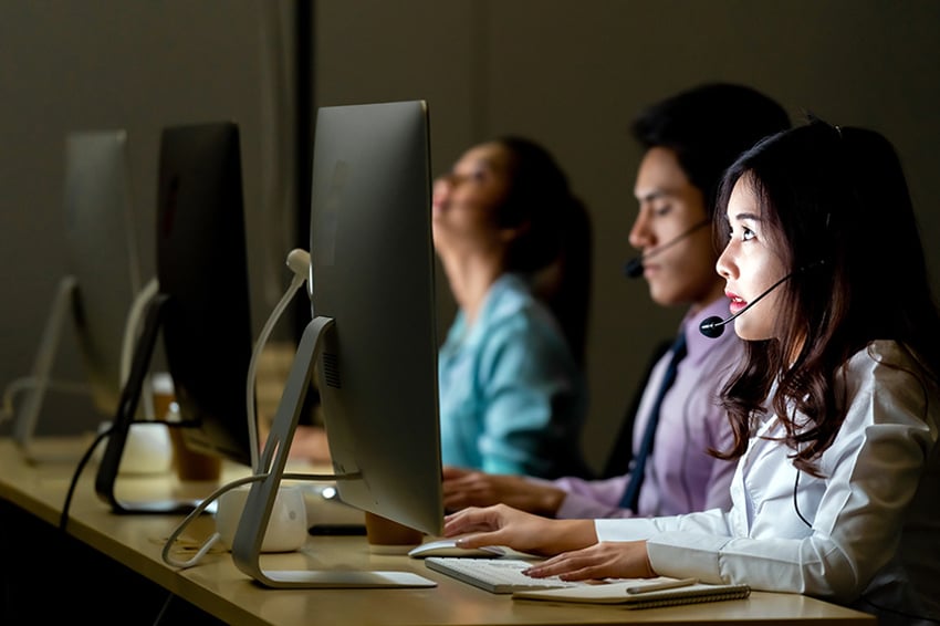 Call center con agentes en monitores de ordenador