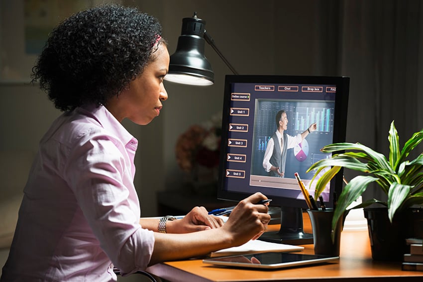 Estudiante en el ordenador mirando una lección de eLearning en pantalla