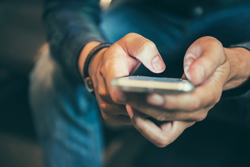 Persona enviando mensaje de texto en teléfono móvil