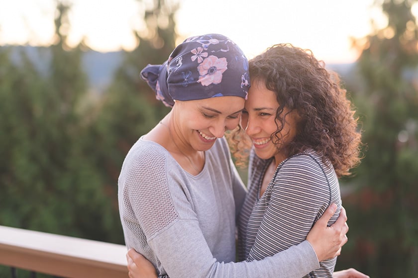 Mujer paciente de cáncer abrazando a su amiga